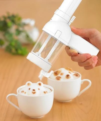 3D latte art maker and two cups of lattes with 3D bears made from milk on top