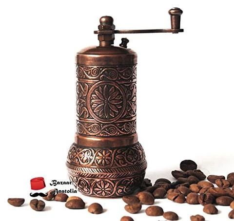 Turkish coffee grinder surrounded by beans